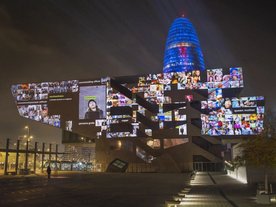 A modernist building at night with a collage of digital images generated by machine intelligence projected onto it.