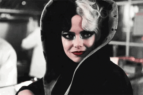 Emma Stone in Cruella doing an eyeroll while wearing her characteristic black and white Cruella identity like a costume.