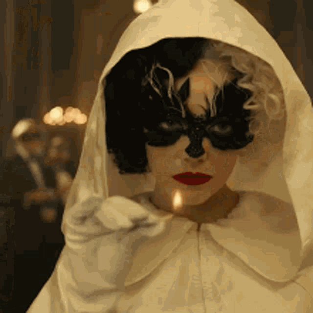 Emma Stone in Cruella. She's wearing a white dress on a black and white ball. The dress burns away in a flash fire and reveals a red dress underneath. Cruella stays calm throughout it while the room recoils.