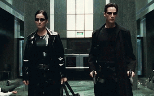 Neo and Trinity in the lobby looking at each other.