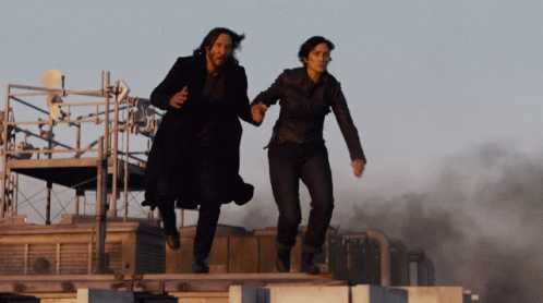 Neo and Trinity jumping hand in hand from a building in Resurrections.