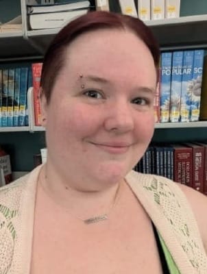 A selfie of Kaye Crawford smiling in the library