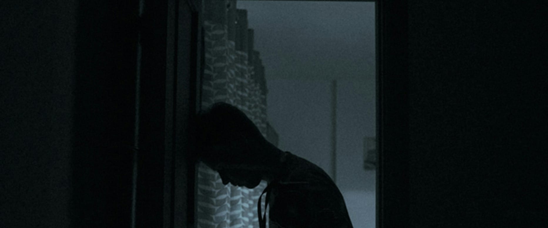 person in black jacket standing near window