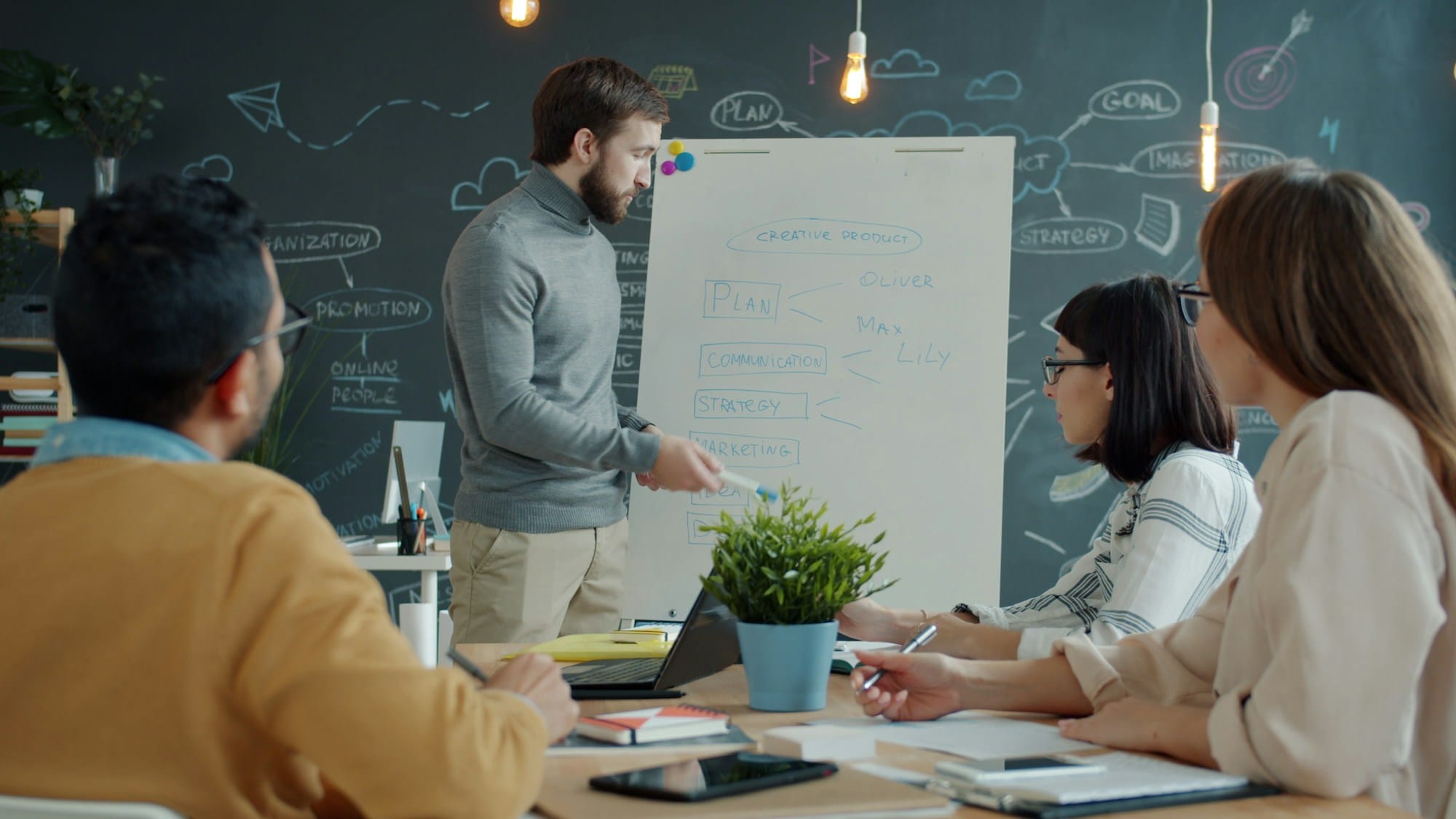 A team collaborating around a whiteboard in a modern office, evoking the planning workshops that should produce a defensible 90-day Agentforce pilot.