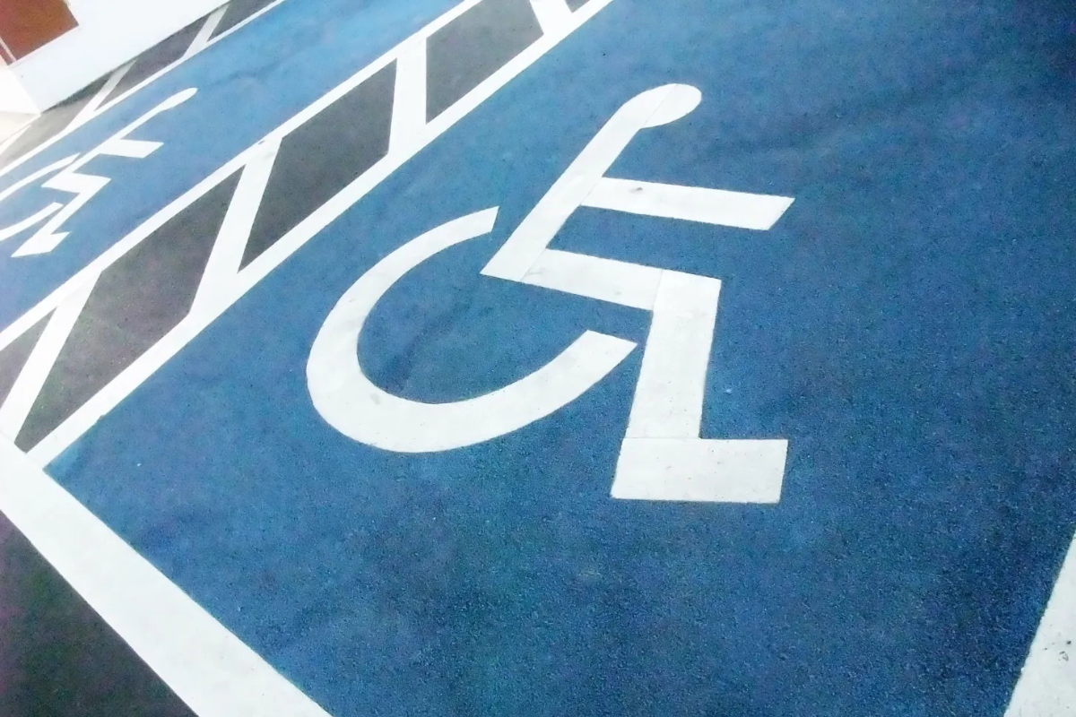 White on blue wheelchair symbols painted on pavement, marking two accessible parking spaces