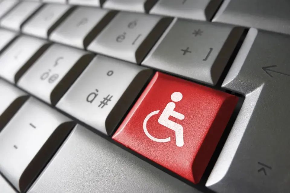 While wheelchair symbol on a red computer keyboard key, surrounded by white keys