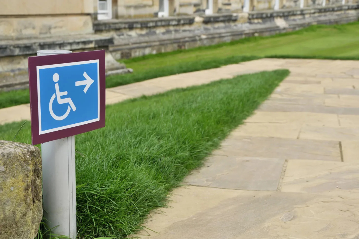 White on blue wheelchair sign marking an outdoor accessible path