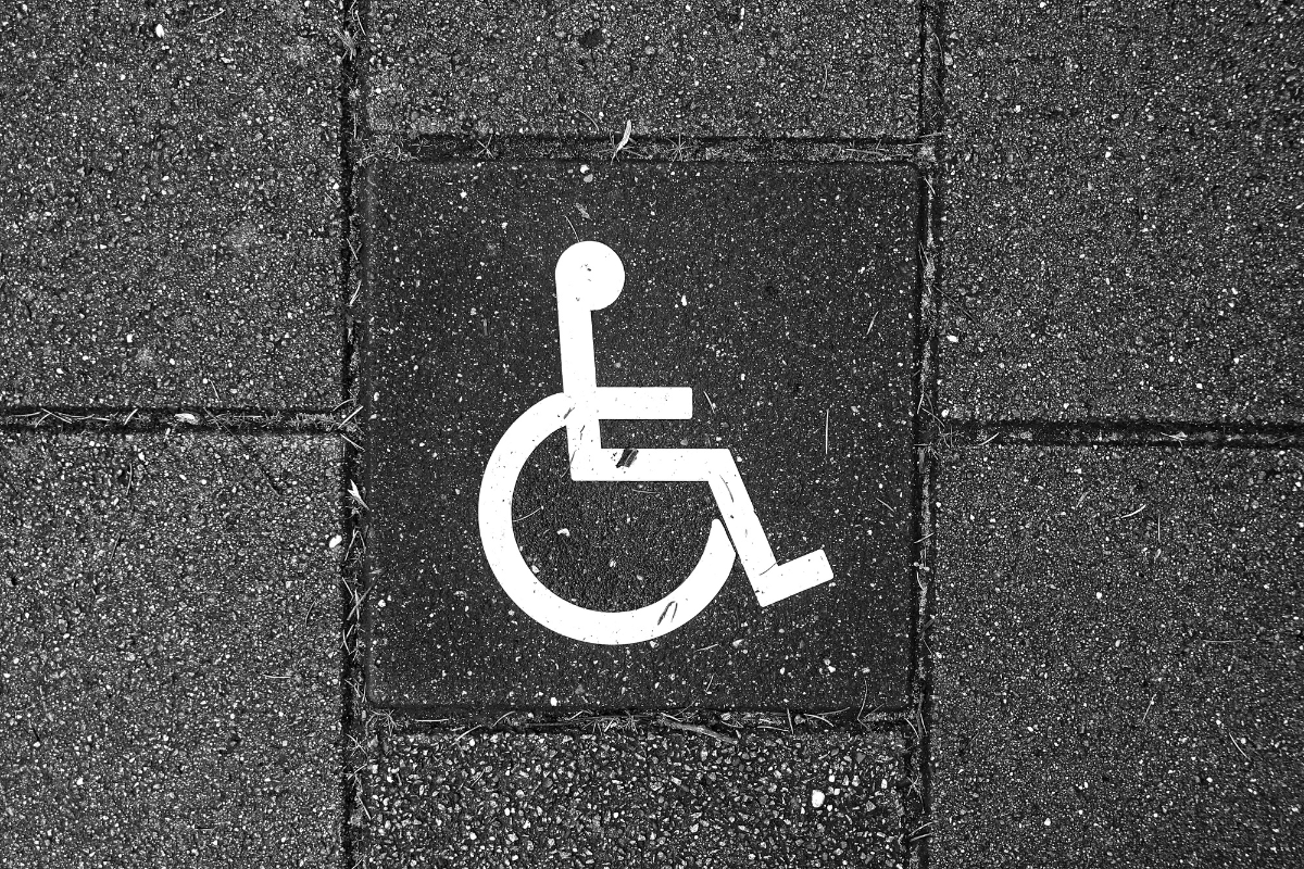 White wheelchair symbol on a black brick wal