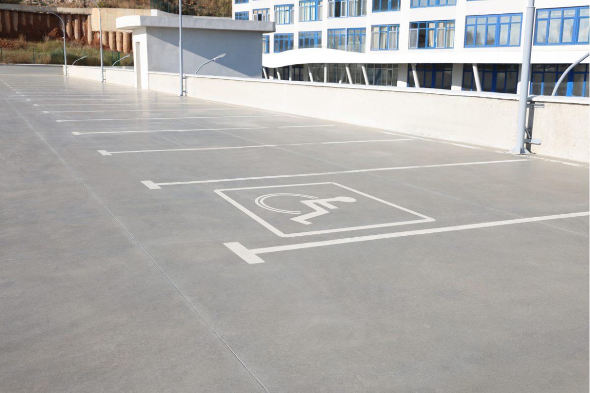 White lines and wheelchair symbol on pavement marking accessible parking space