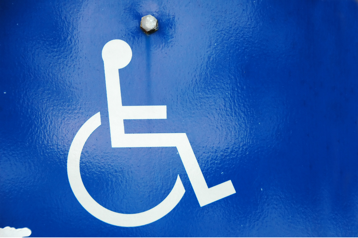White wheelchair symbol on a textured blue backgroun