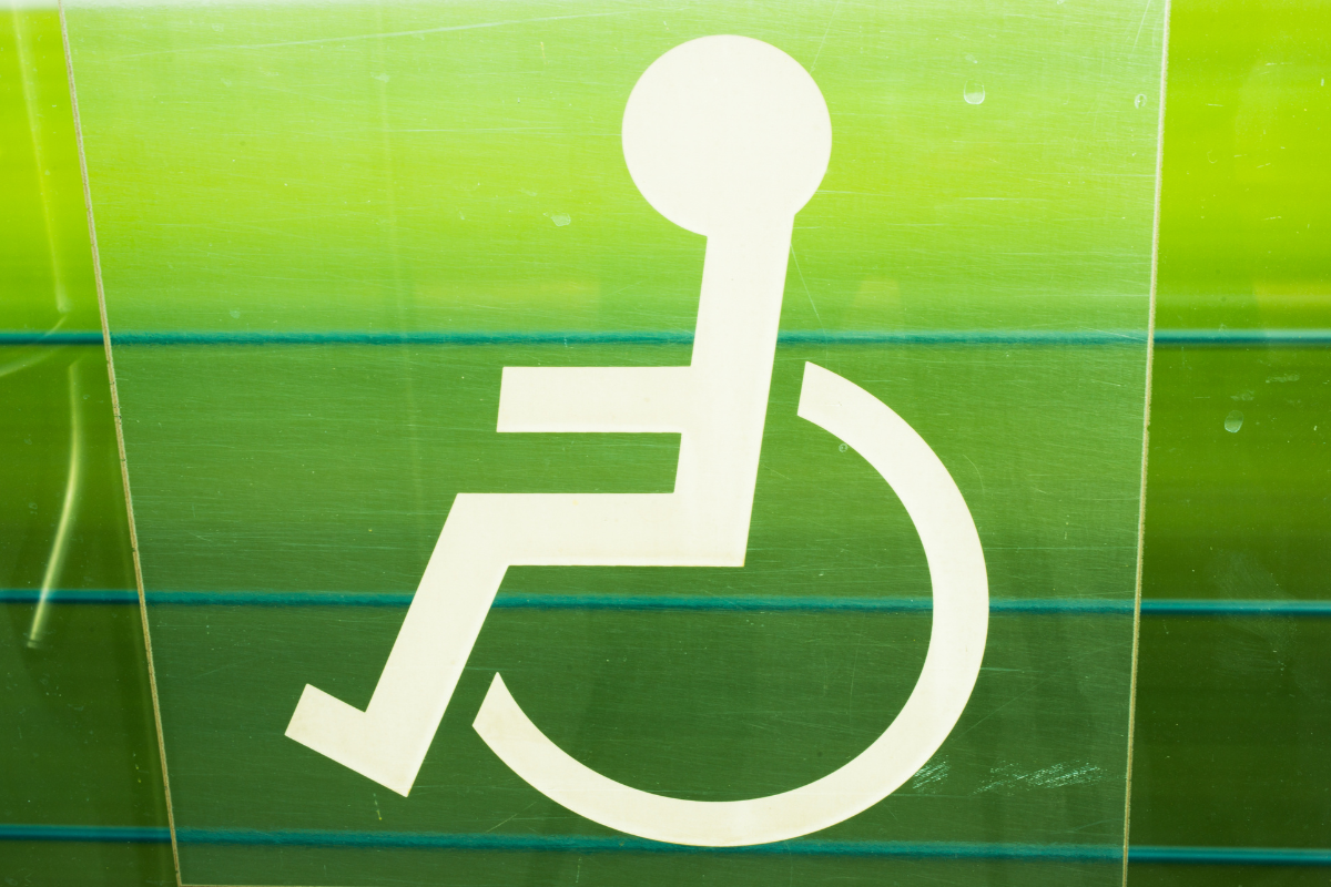 White wheelchair symbol on green-tinted panels