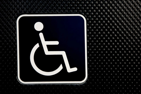 White wheelchair symbol on a black background, textured on the right