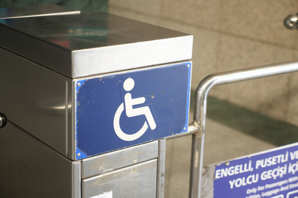 White wheelchair symbol on blue panel on a pedestrian gateway