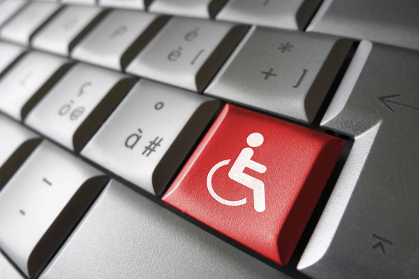 Closeup of computer keyboard with one red key with a white wheelchair symbol
