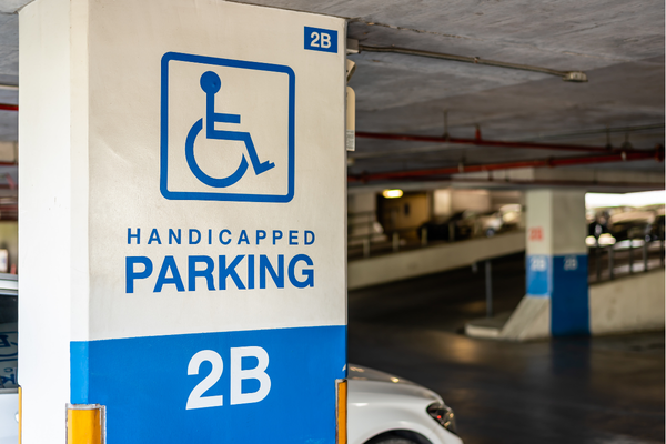 "Handicapped Parking" sign with a blue wheelchair symbol inside a public garag