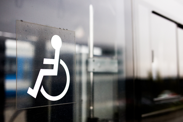 White wheelchair symbol sign on reflective glass doo