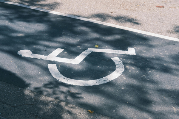 White on blue wheelchair symbol painted on pavement marking accessible parking space
