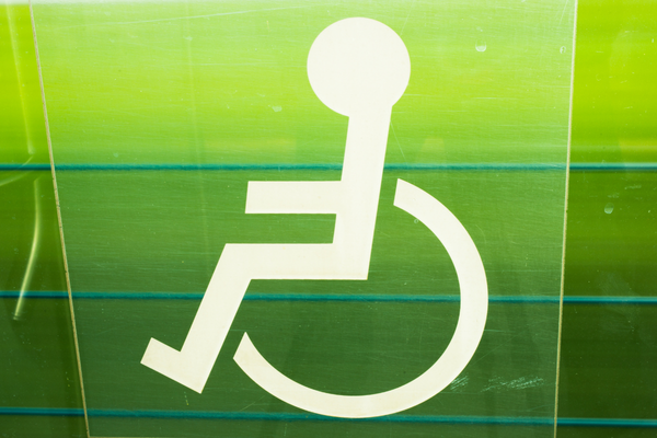 White wheelchair symbol on green-tinted panels
