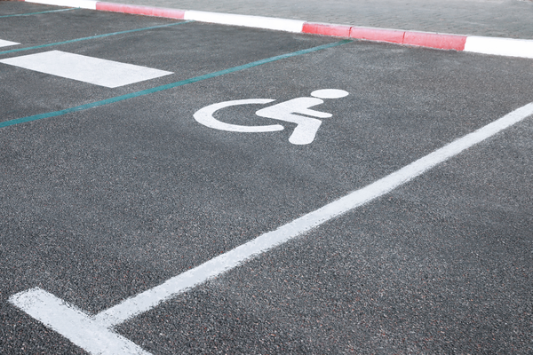 White wheelchair symbol and lines marking accessible parking space