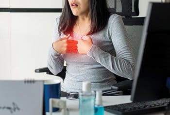 Woman at desk with heartburn