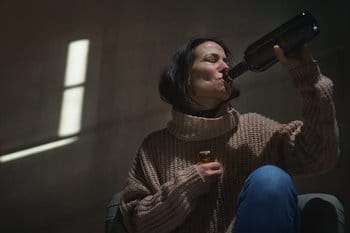 Woman drinking from wine bottle
