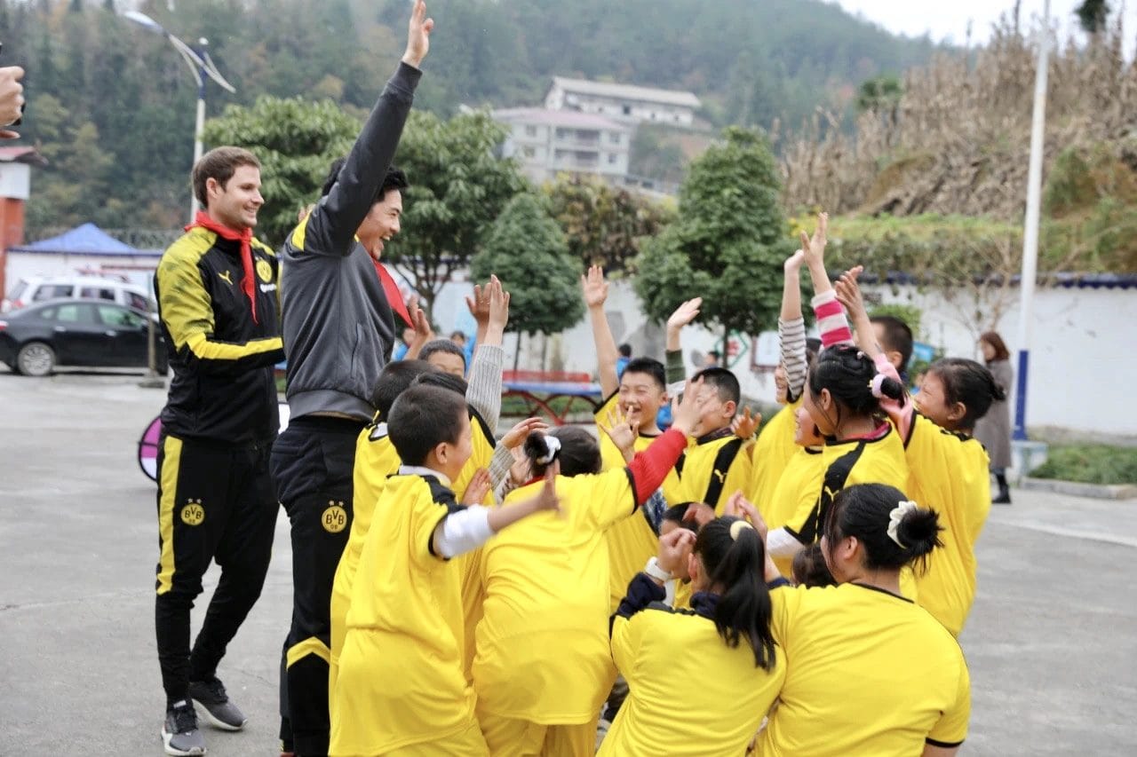 Martin Zhang celebrating with children at a Borussia Dortmund football clinic in China