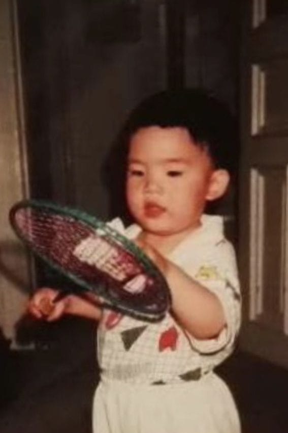 Martin Zhang as a toddler holding a badminton racket