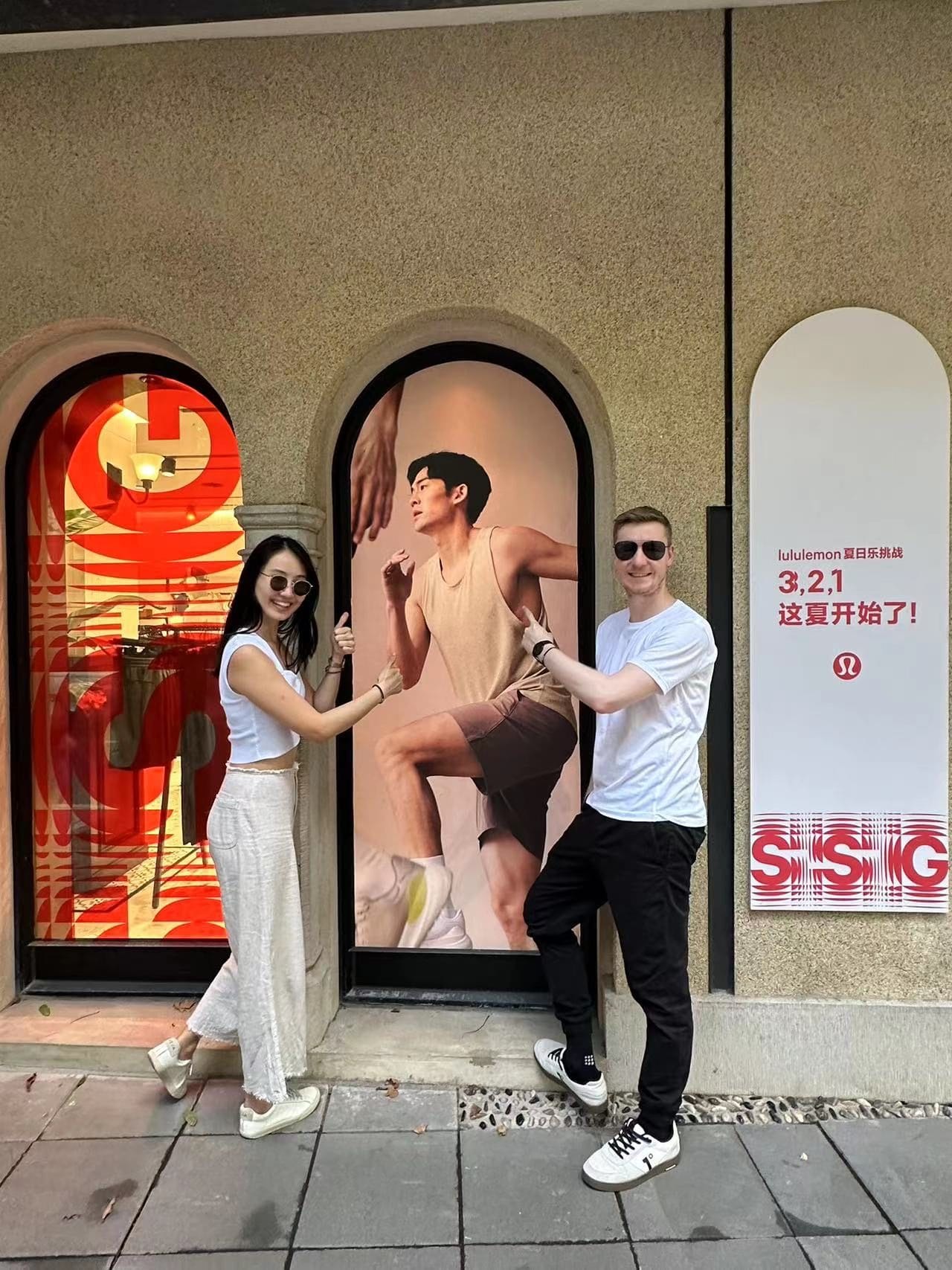 Martin Zhang and friends posing in front of his own lululemon campaign on a Shanghai storefront