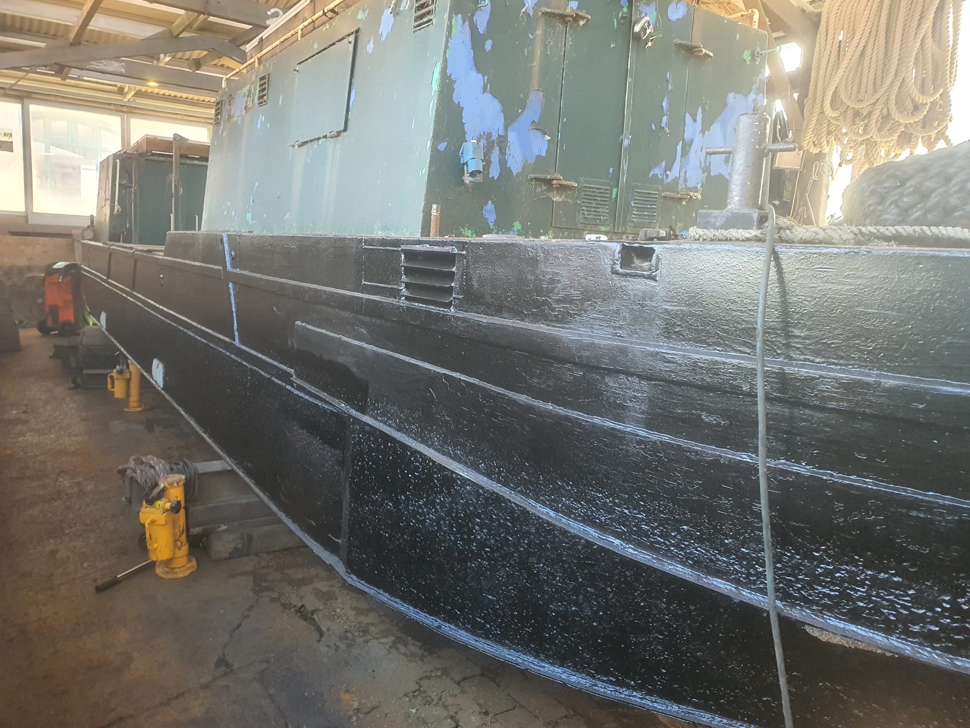 The lovely curvy bum of a narrowboat all shiny and coated in bitumen