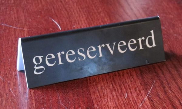 Sign on table reading "reserved" in Dutch