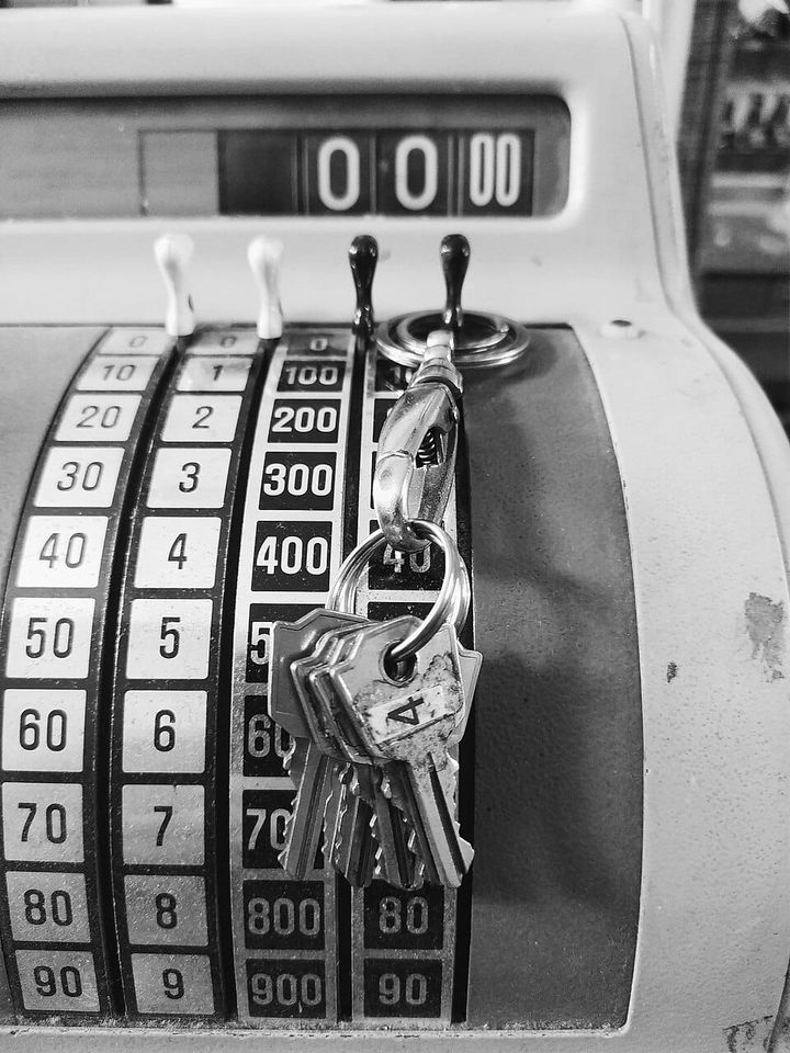 A black and white photo of an old cash register.