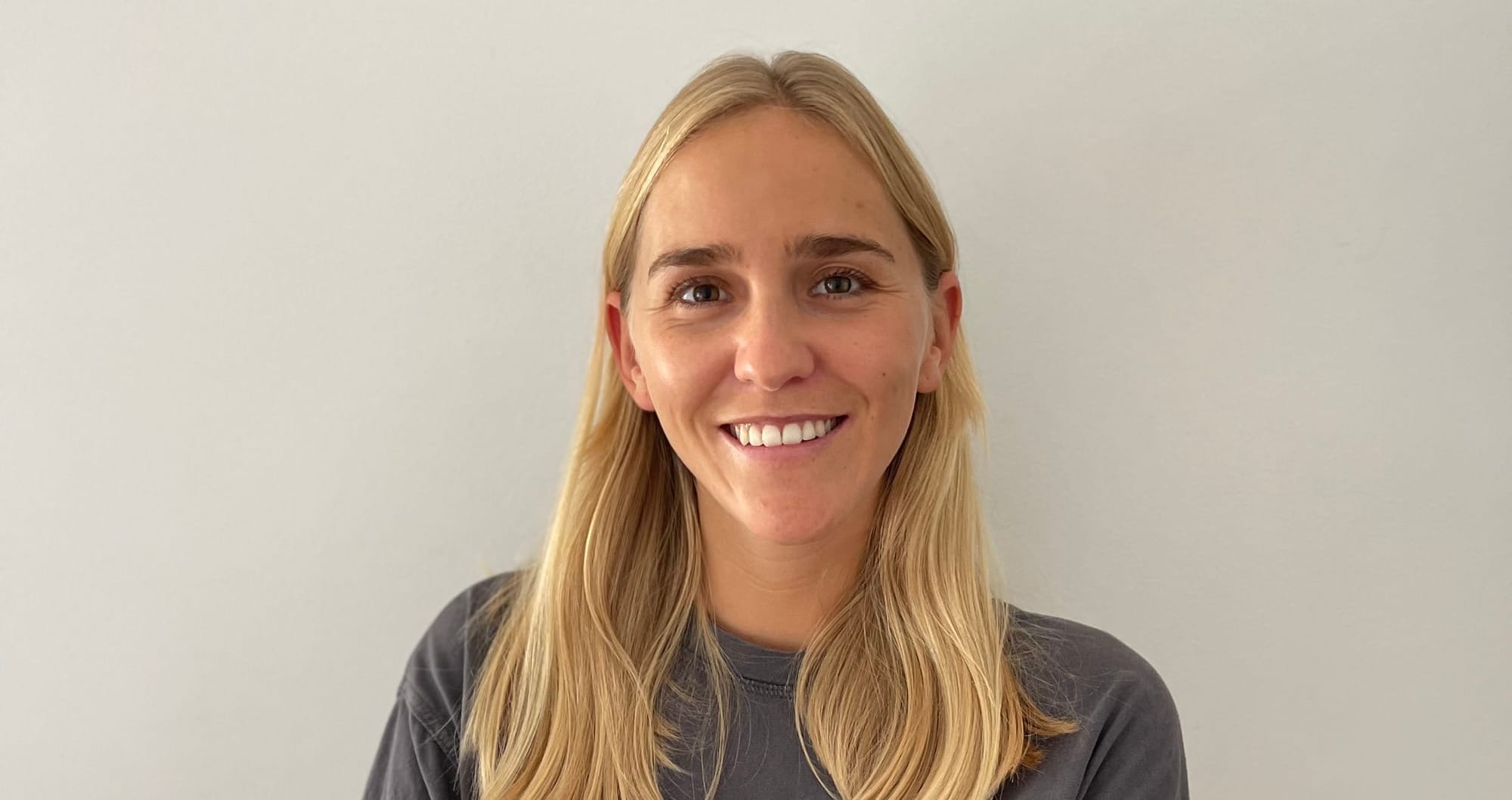 Headshot of a smiling woman with long blonde hair.