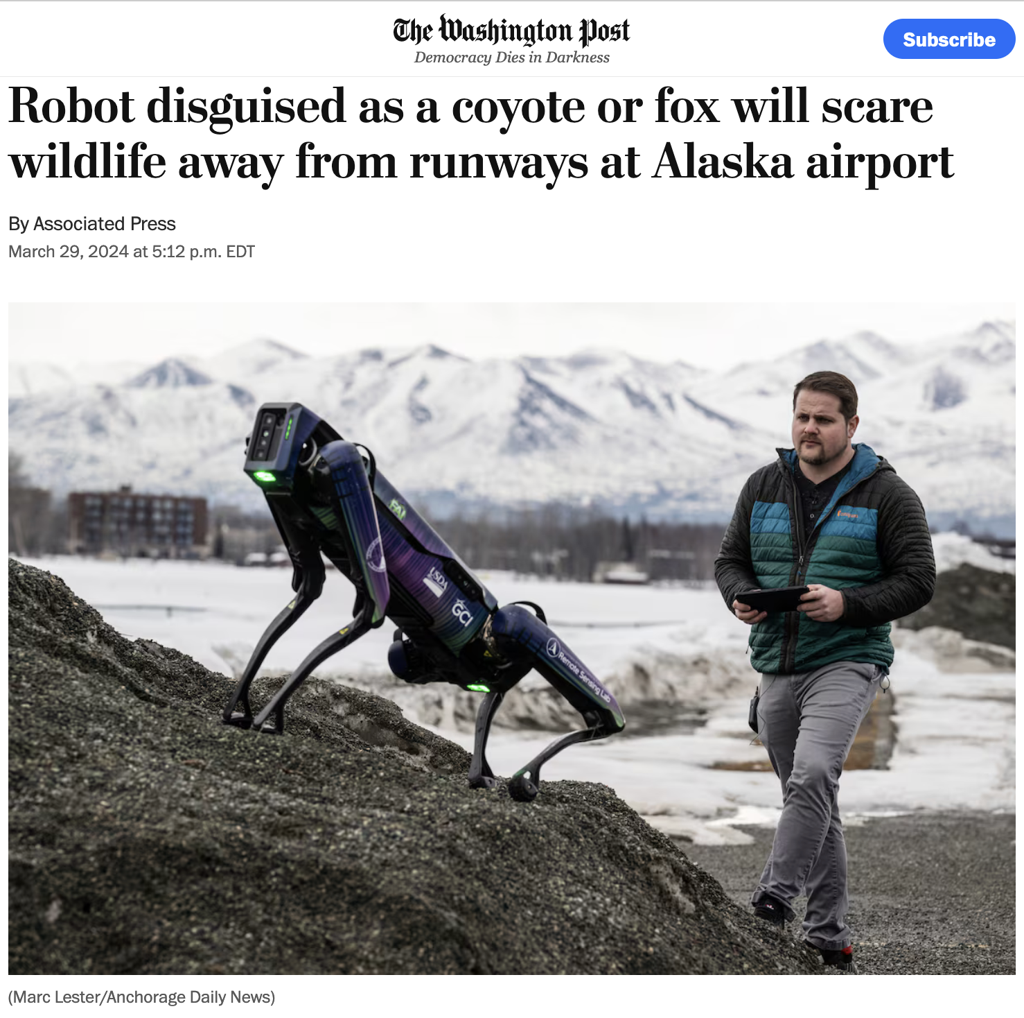 Aurora, a four-legged robot, poses on the foothills of the Alaskan mountains with a human operator standing nearby.