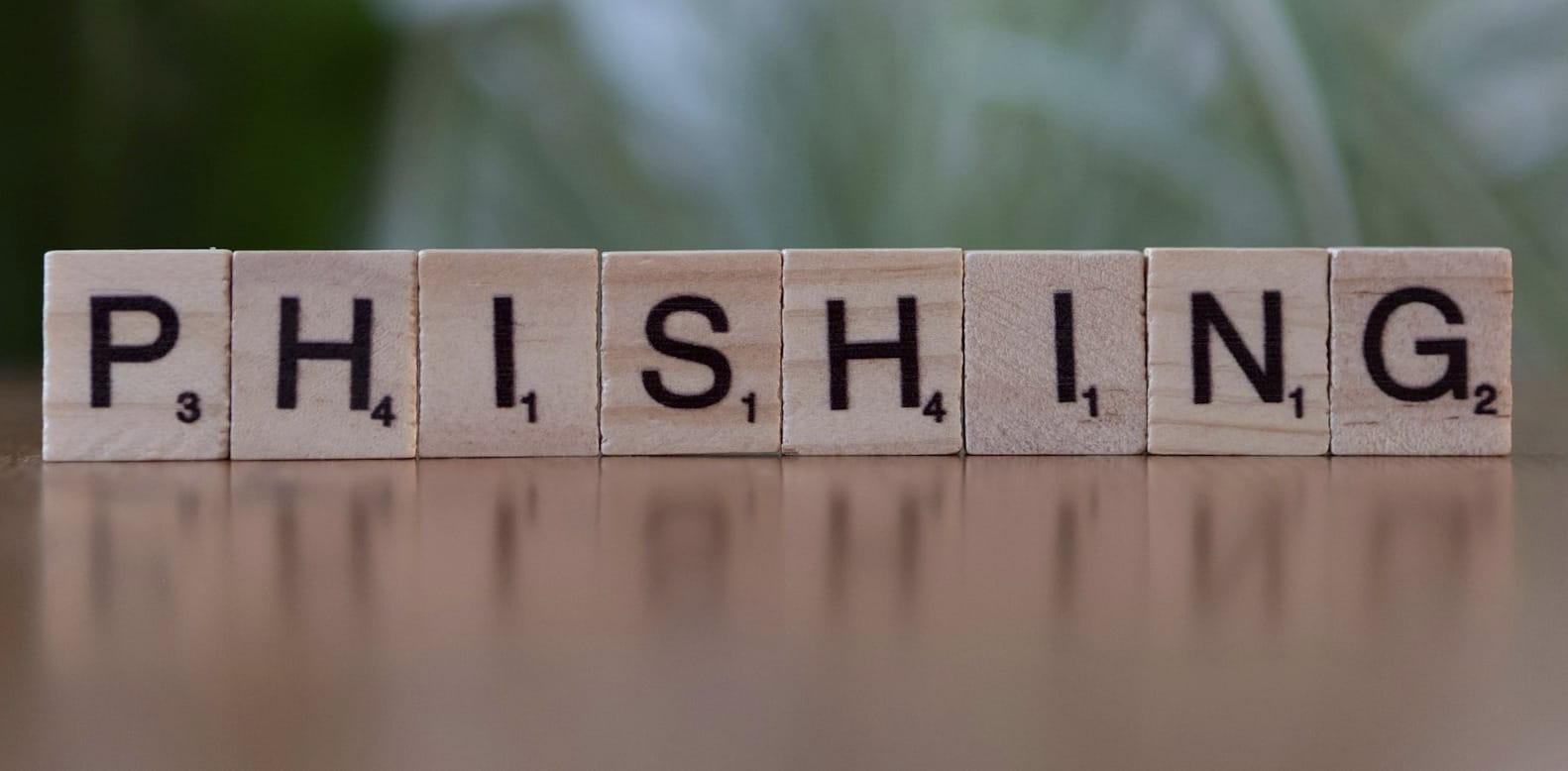 A wooden block spelling phishing on a table