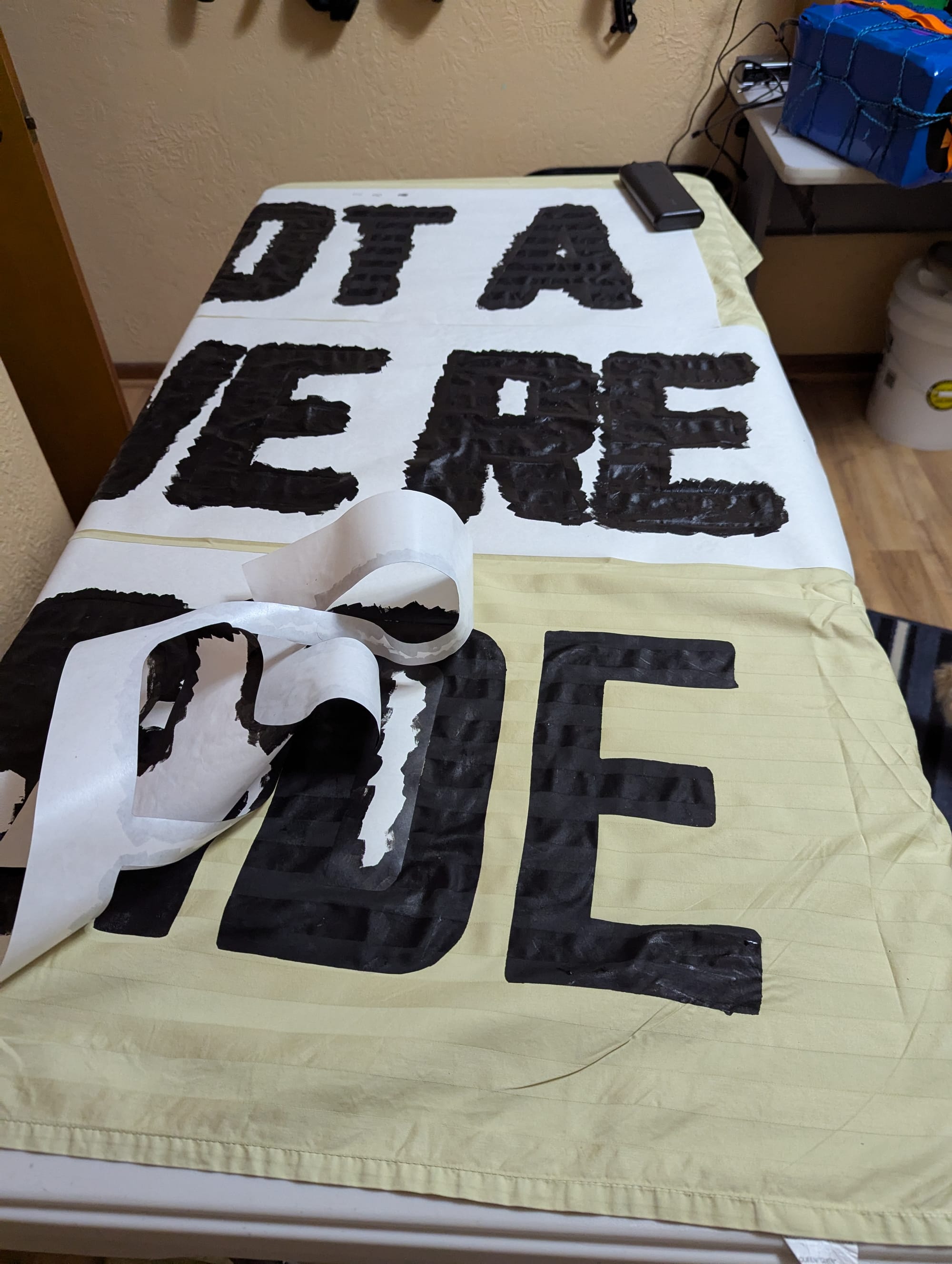 The banner with the stencil being removed. The lines of each letter are smooth and clean, except for one little blip on the bottom of the last E.