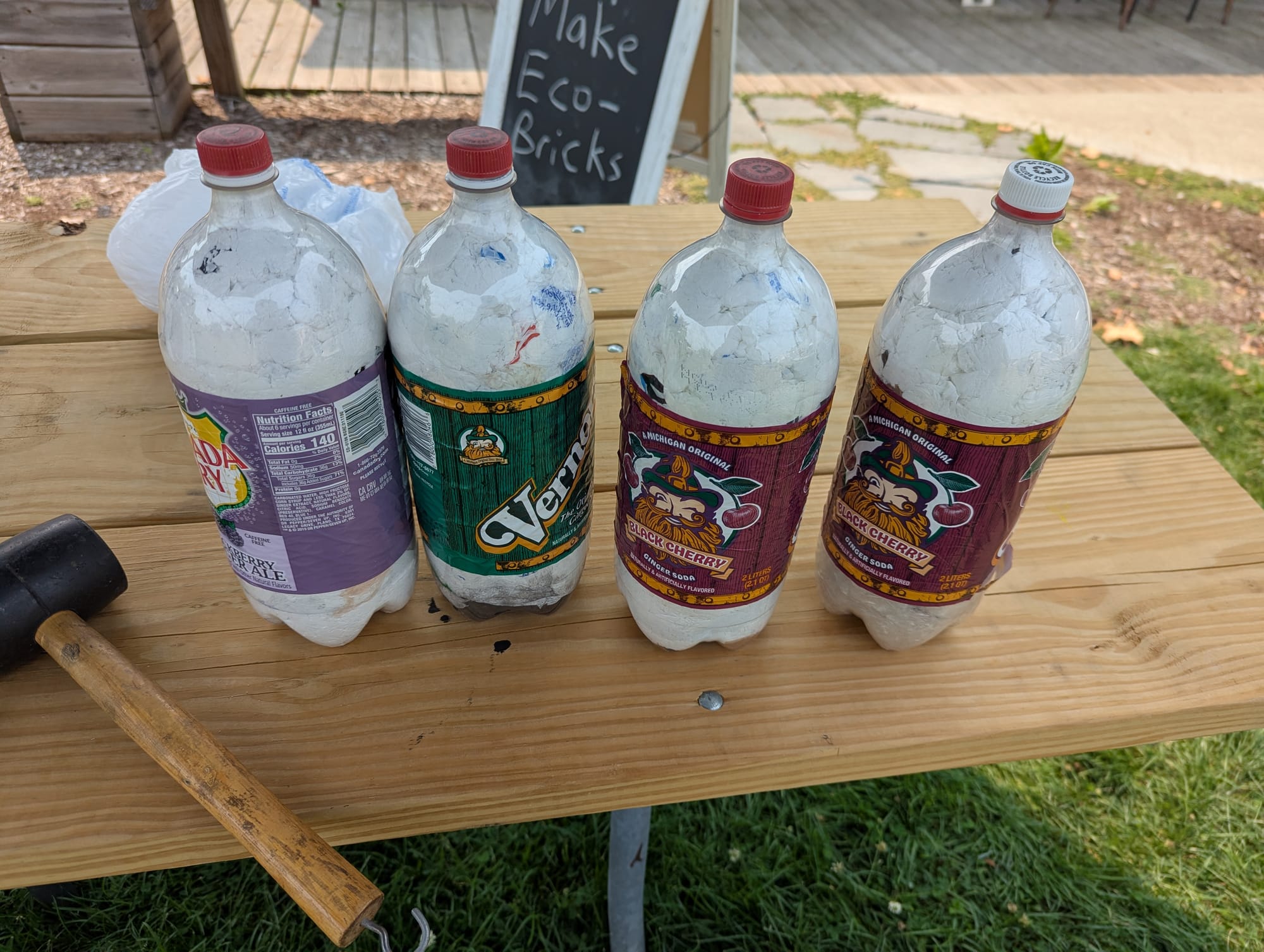Four 2-Liter soda bottles that have been filled with plastic shopping bags