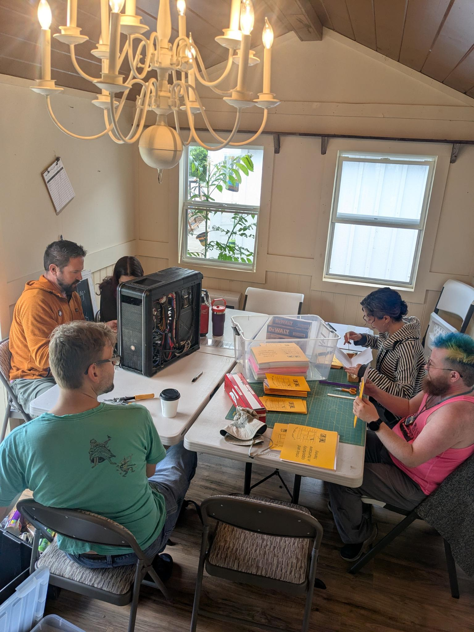 Various members of the Commoners making zines, folding plant tags, and recycling computers.