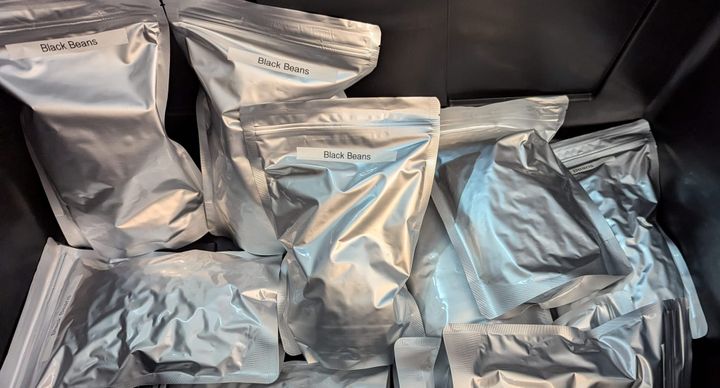 A pile of silvery Mylar bags filled with black beans