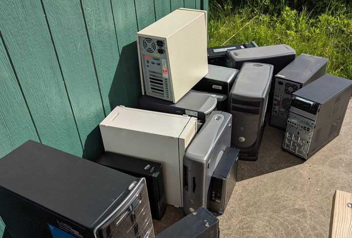 A large herd of computer towers clustered together next to the shed at the Farmer's Market pavilion