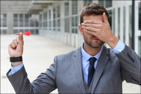A person in a suit holding a dart in his hand

AI-generated content may be incorrect.