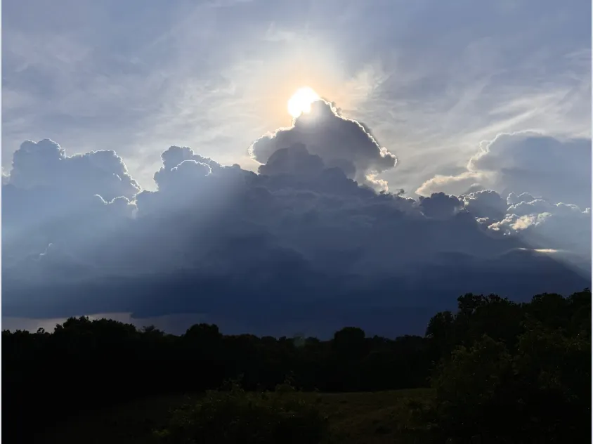 Severe thunderstorm warning 06/11 6:25pm with sun getting shrouded by a thunderhead