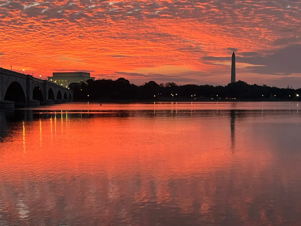 Orange and gray hues in the dawn sky above the Potomac River and Memorial Bridge.