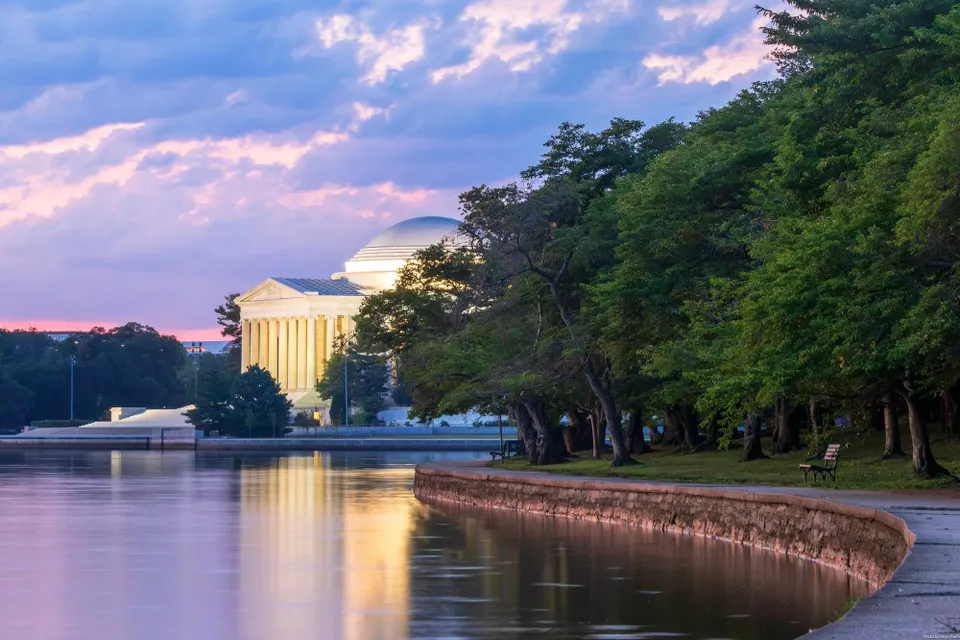 A colorful dawn sky above the Jefferson Memorial and tree-lined Tidal Basin.