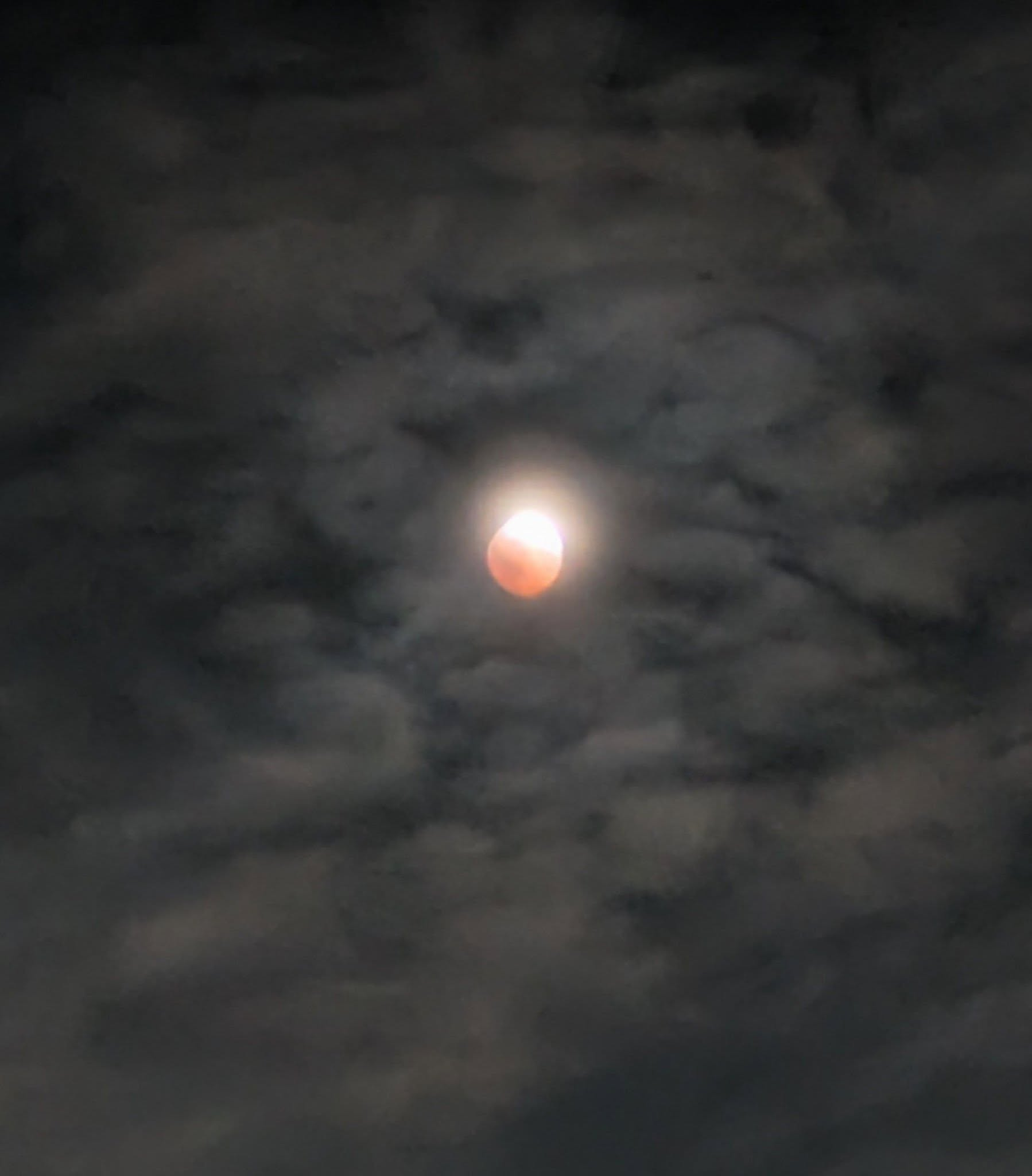 The deep lunar eclipse through the clouds in Takoma, DC Thursday night.