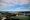 The Jefferson Memorial and Reagan National Airport are seen near the center of a photo on aparty sunny day. Much of the ground area is taken up with the Tidal Basin, Potomac River.