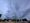 Very dark skies over a parking lot - an ominous cloud and street lamps have come on