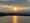 Photo of sun rising through mixed skies above the Potomac on Monday.