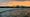 Orange skies and light waves on the Potomac River. There's also a bridge in the middle of the frame. 