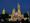 The Smithsonian Castle is all lit up like stained glass for an art exhibit at night. 