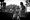People sing and play instruments in a black and white photo from the Fort Reno summer concert series.